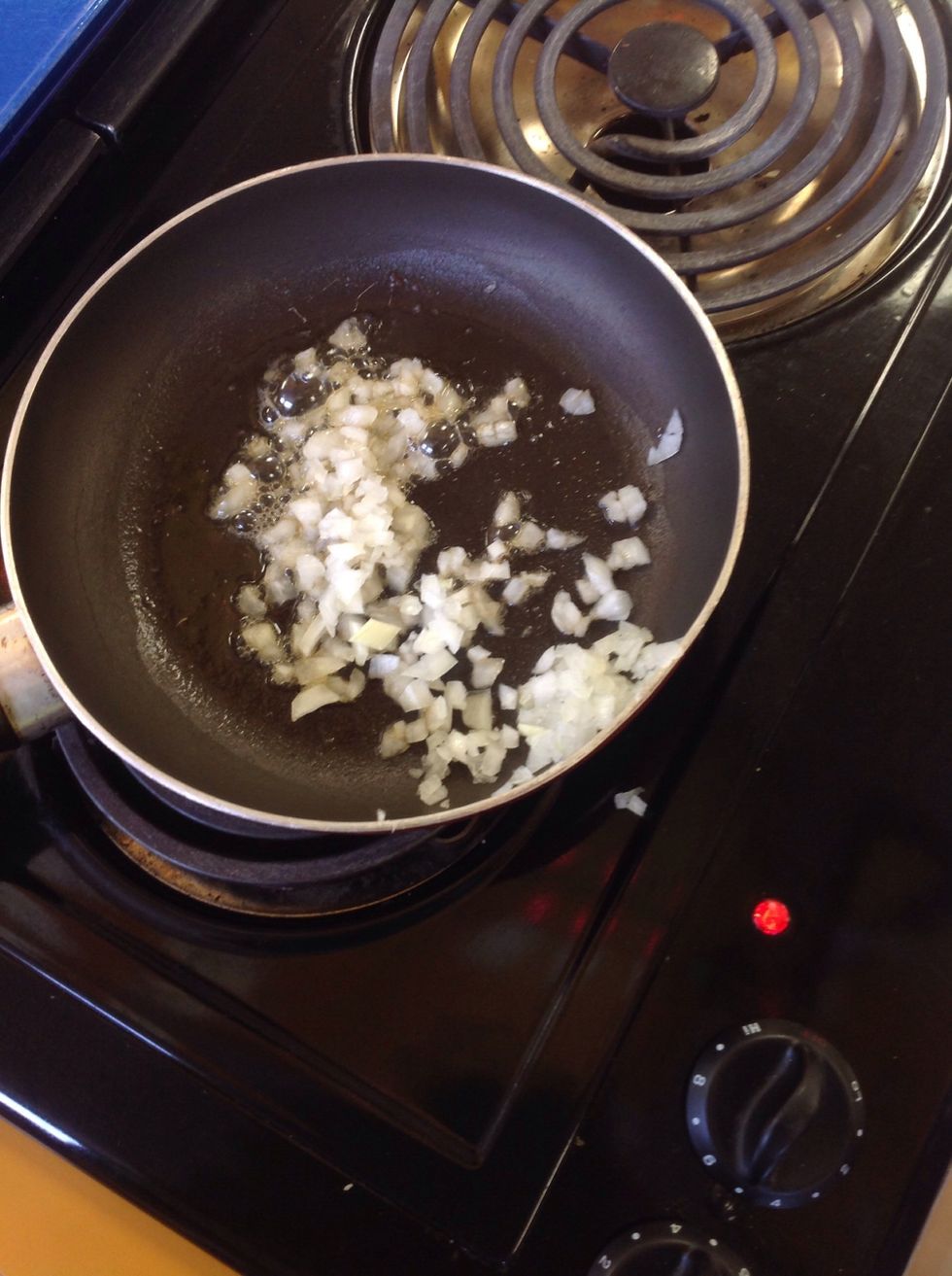 Saut\u00e9 the onion in the pan with margarine, stir constantly using the rubber scrapper. Cook the onions until they are translucent.