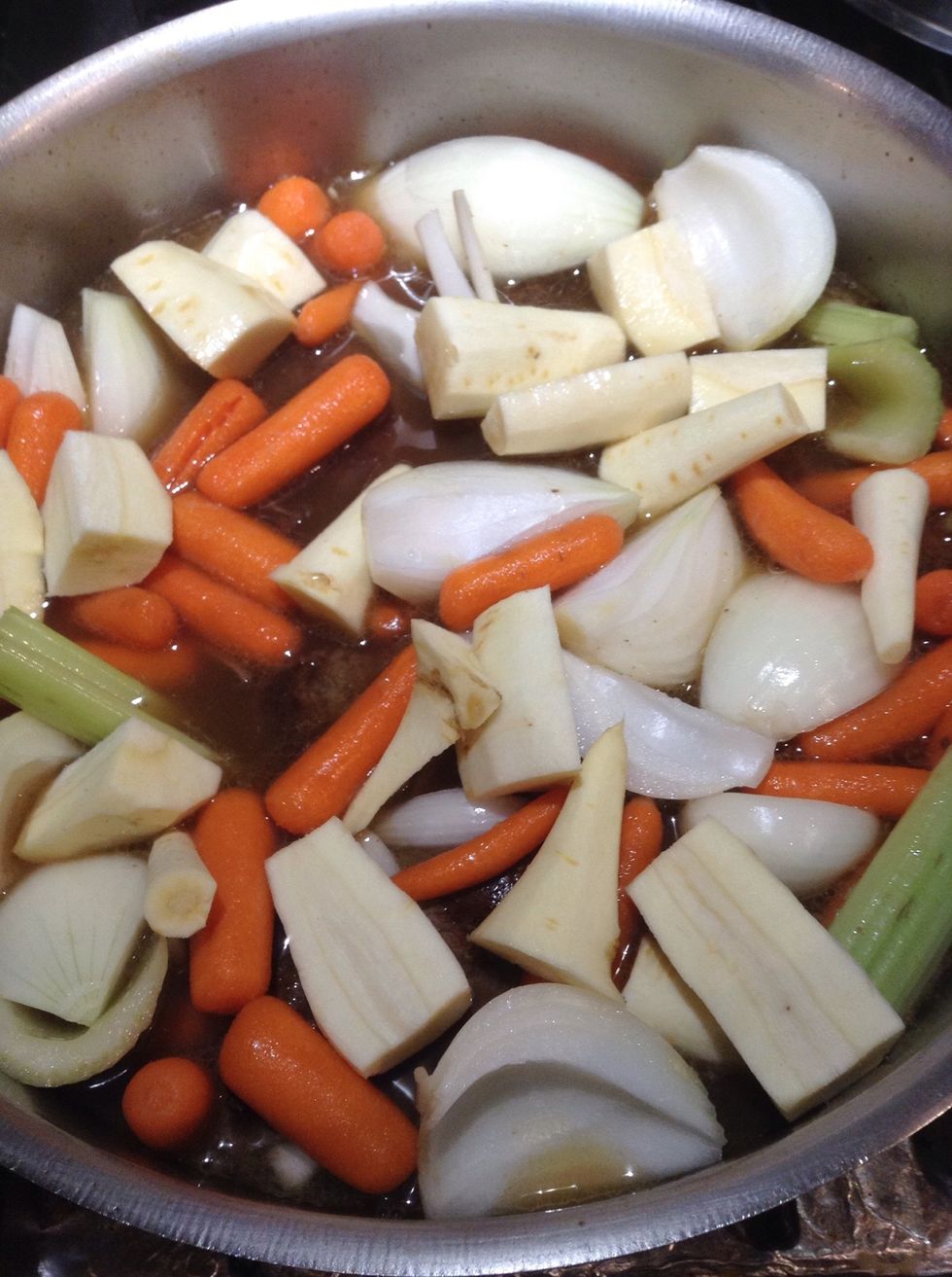 Saut\u00e9 vegetables until lightly brown then deglaze pot with stock and optional wine.  Add meat and any accumulated juices along with spices mix lightly