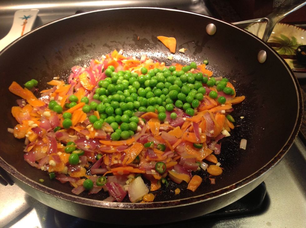 Saut\u00e9 with chiles and garlic for a couple minutes, add peas, and give it a stir.