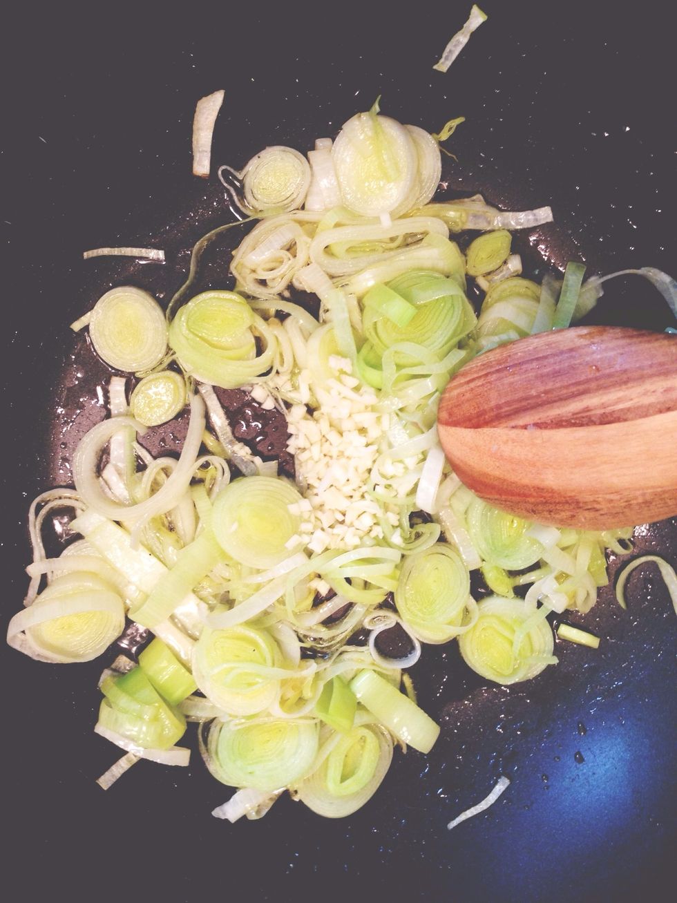 Saut\u00e9e the chopped leeks in a medium-hot pan with a drizzle of olive oil. Once tender, add 2 minced cloves of garlic and saut\u00e9e further, (about three more minutes).