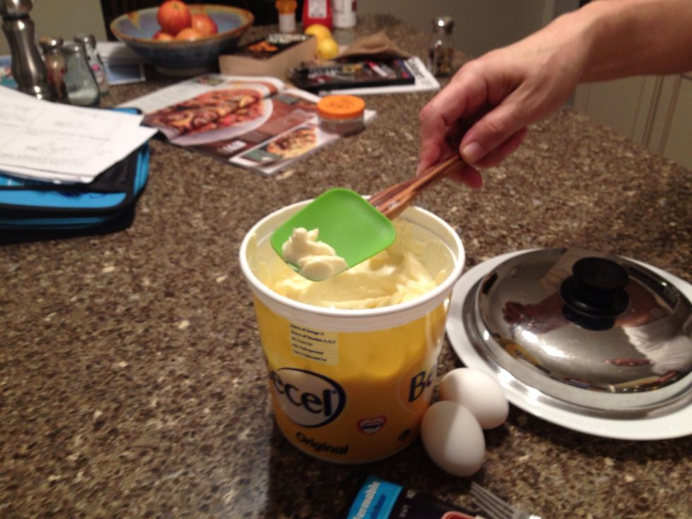 Scoop a chunk of butter out of the container and put it on the pan
