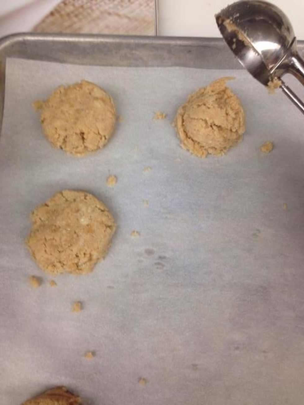 Scoop about 2 tablespoons of dough onto a sheet tray lined with parchment paper. (Slightly flatten dough with your palm).