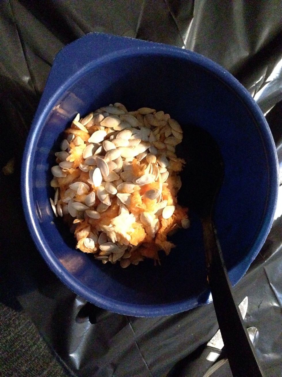 Scoop all the meat and seeds out, and put it ind the bowl. Note: don't through it out, you can toast the seeds and use them as a snack. I'm actually gonna use the meat for some cupcakes.