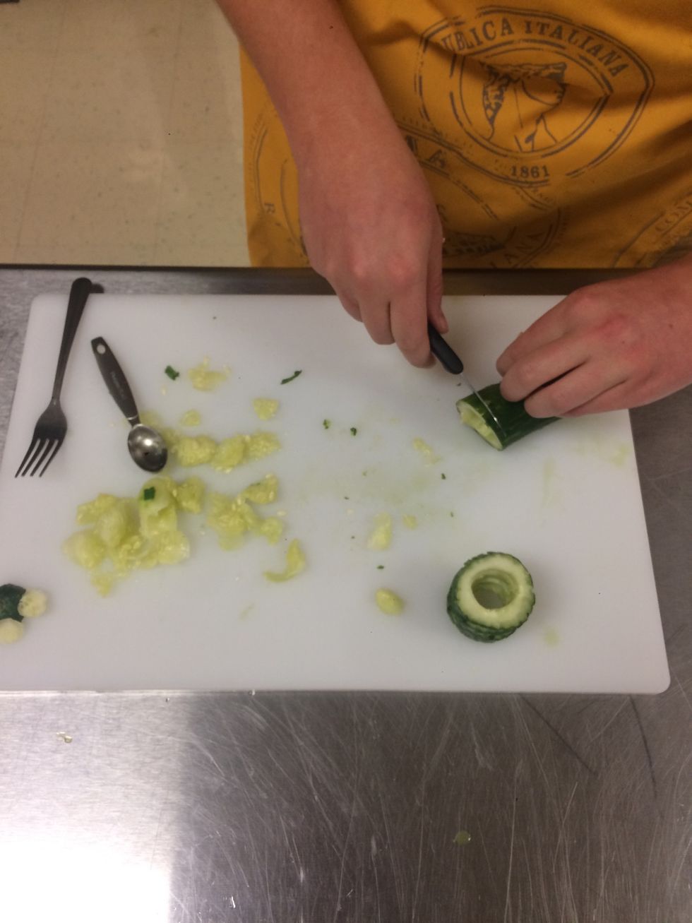 Scoop inside of cucumber. Leave enough room for the cucumber slice to stay intact.