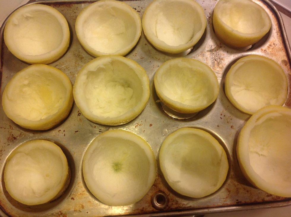 Scoop out fruit. Set in cupcake tin. If needed, trim off end of the fruit with a sharp knife, to make it set flat, being being careful not to puncture through the rind.