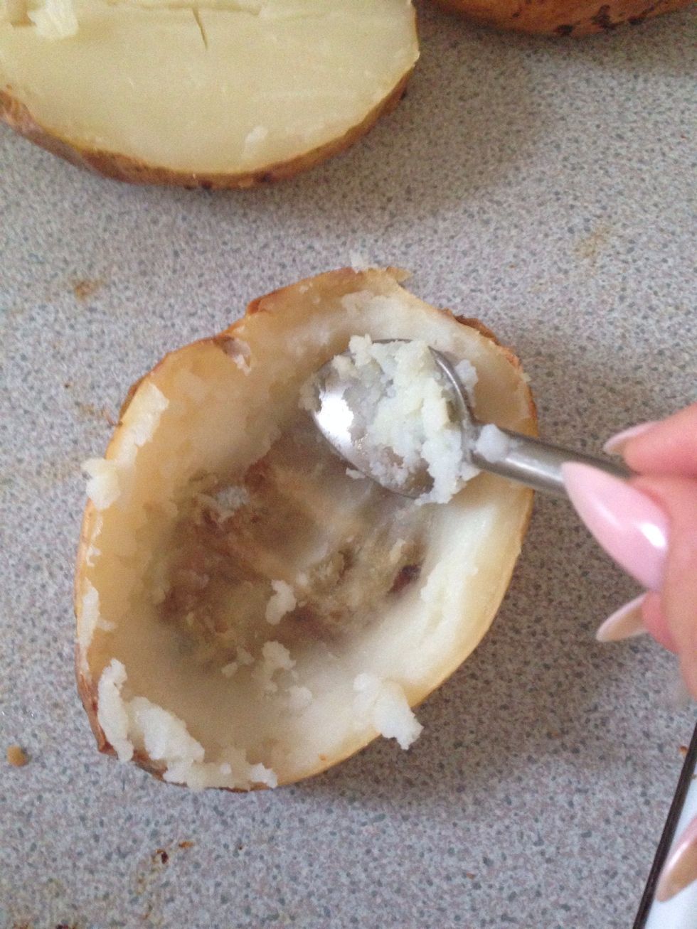 Scoop out the middles of the potatoes and add into a bowl