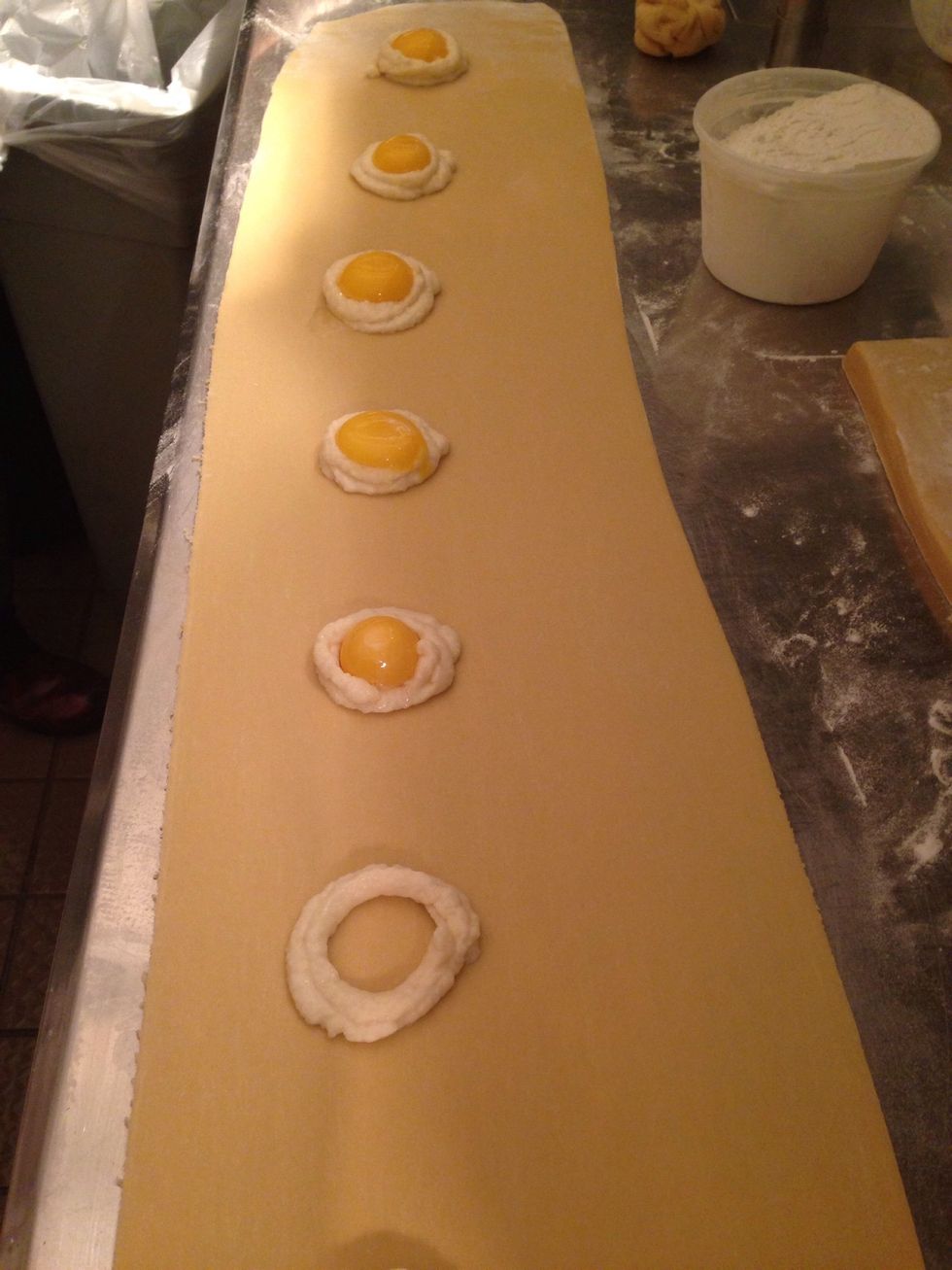 Scoop the celeriac puree on the rolled pasta leaving at least one inch of space in between each scoop. Place the egg yolk in the center of the puree.