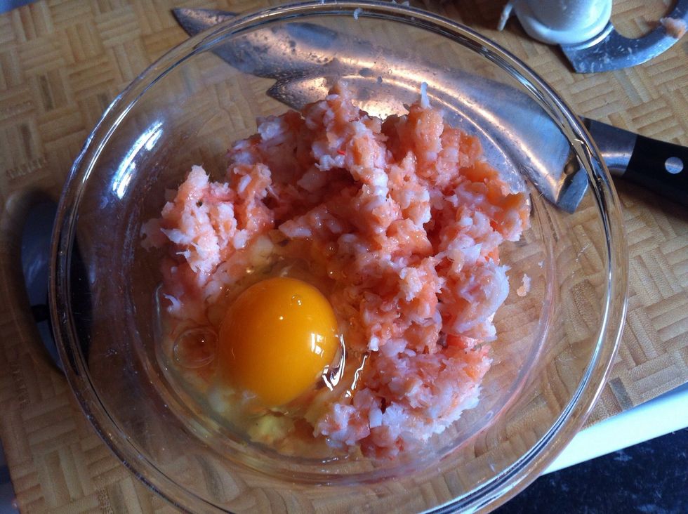 Scoop the contents of the blender into a bowl and crack an egg into the mixture.