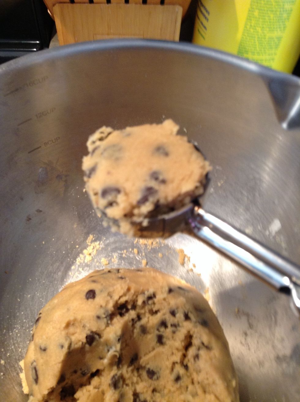 Scoop up some cookie dough with a cookie dough scooper.