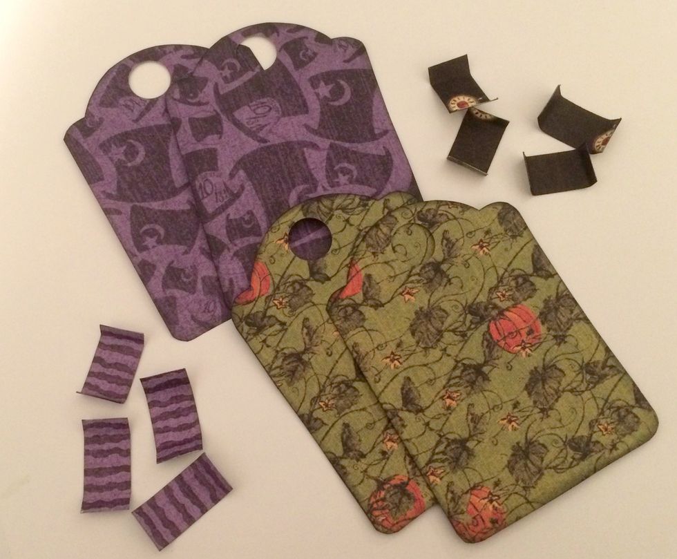 Score 1/2" from the bottom on the patterned paper tags. With a blending tool and Black Soot Distress Ink, ink the edges of the patterned paper tags and the 1/2" x 3/4" pieces.