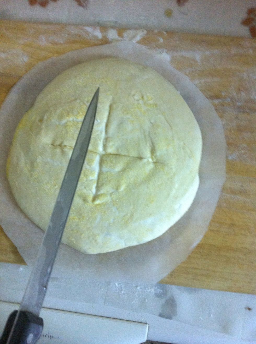 Score a cross on the dough, don't apply pressure, just a slight movement on top of the dough