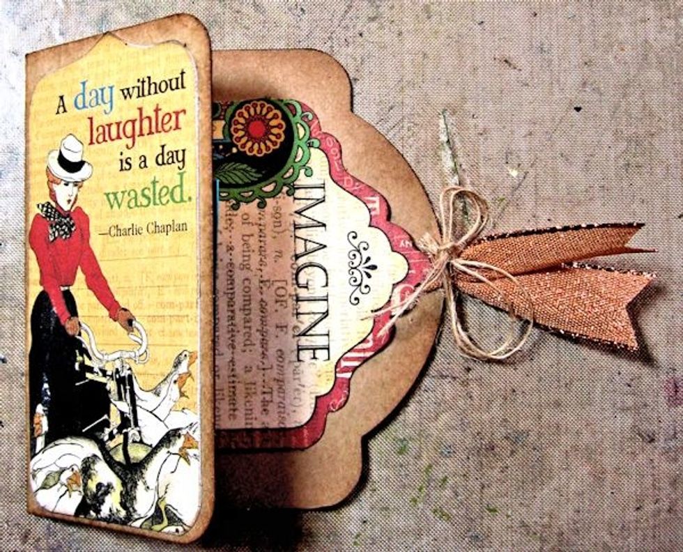 Score a Regular Staples Tag to create a small book.  Decorate with images from Tags and pockets. Thread ribbon through the grommet and tie with burlap string.