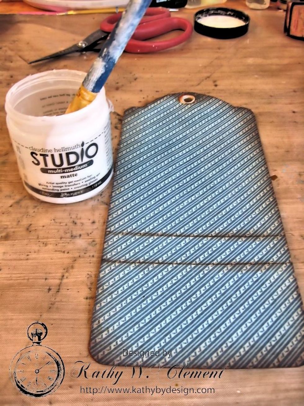 Score each piece at 2.25" and 3", just as you did for the ivory tag.  Crease to form pockets.  Ink all edges with Vintage Photo Ink. Use a gel medium to glue onto the the ivory tag base.