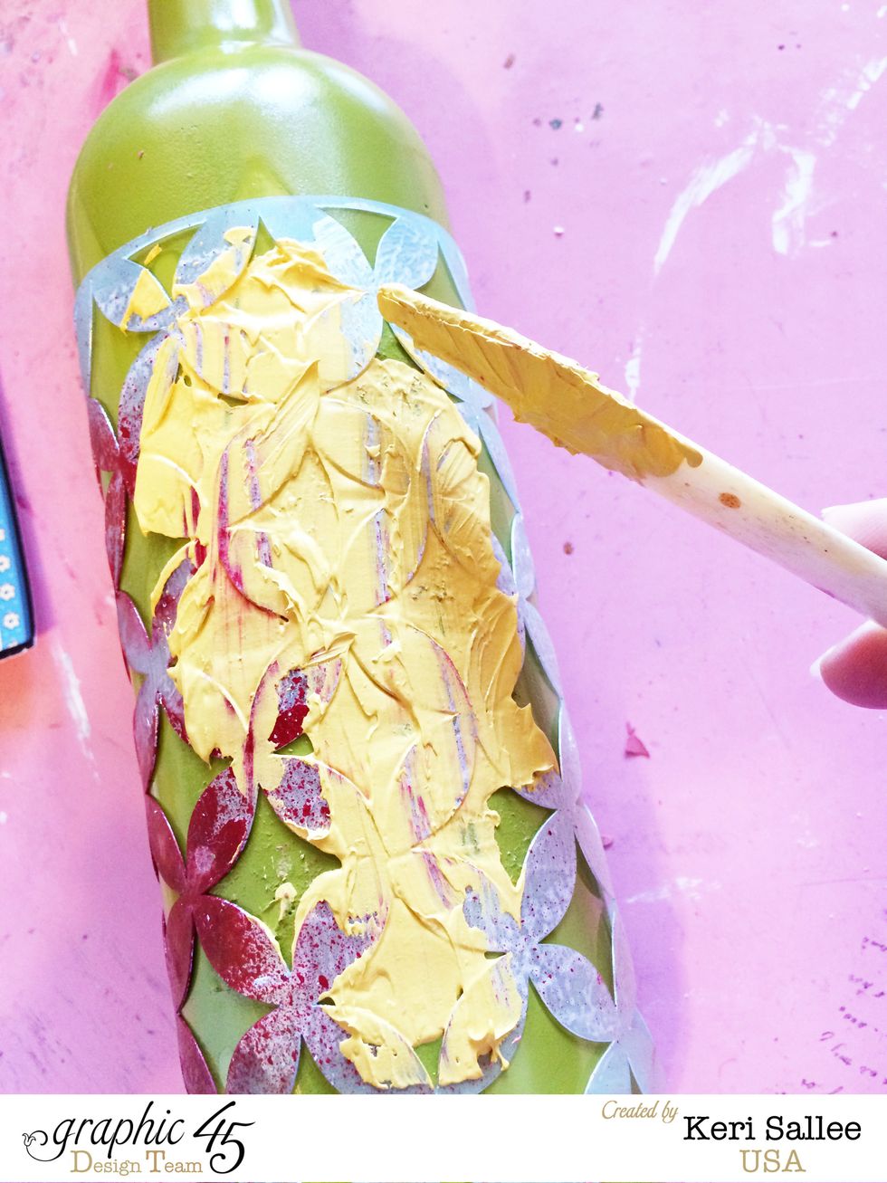 Scrape your modeling paste through your stencil. As you can see...I didn't clean this stencil the last time I used it, so I ended up with some read mixed in with my yellow. :) I like it!