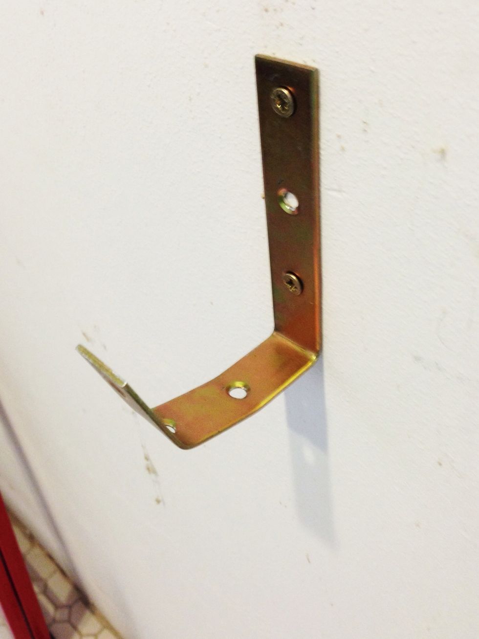 Screw a large L-bracket to the wall and bend it a little, you'll end up with a hook like this.