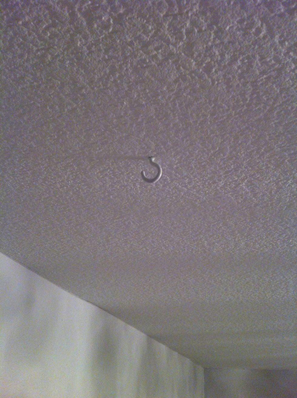 Screw a small hook into the ceiling. Measure first so it's centered above your crib.