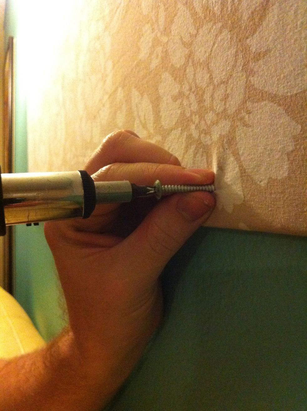 Screw it to the wall right through all the layers. My husband used a ratcheting screwdriver, but you could use a regular screwdriver or a drill fitted with a screwdriver bit. We used 2" long screws.
