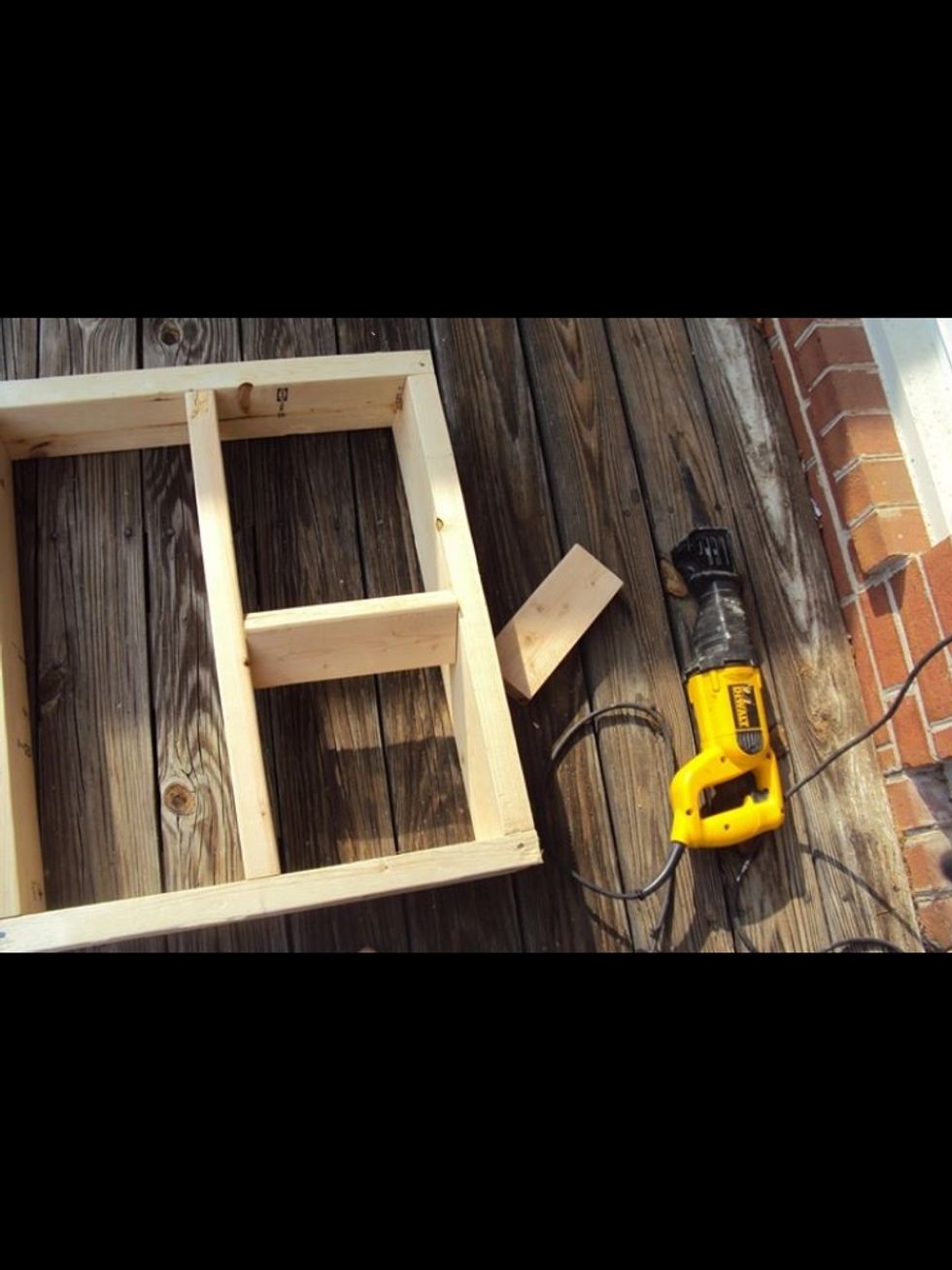 Screw the 4 2"x6" boards together as shown making a box with the single 2 foot long 2"x4" in the middle. Next start attaching the 2 10" long 2"x4" in the middle.