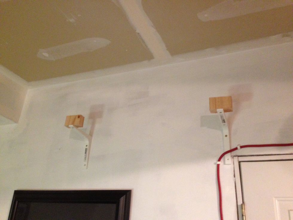 Screw the shelf brackets to the wall with the wood facing up.