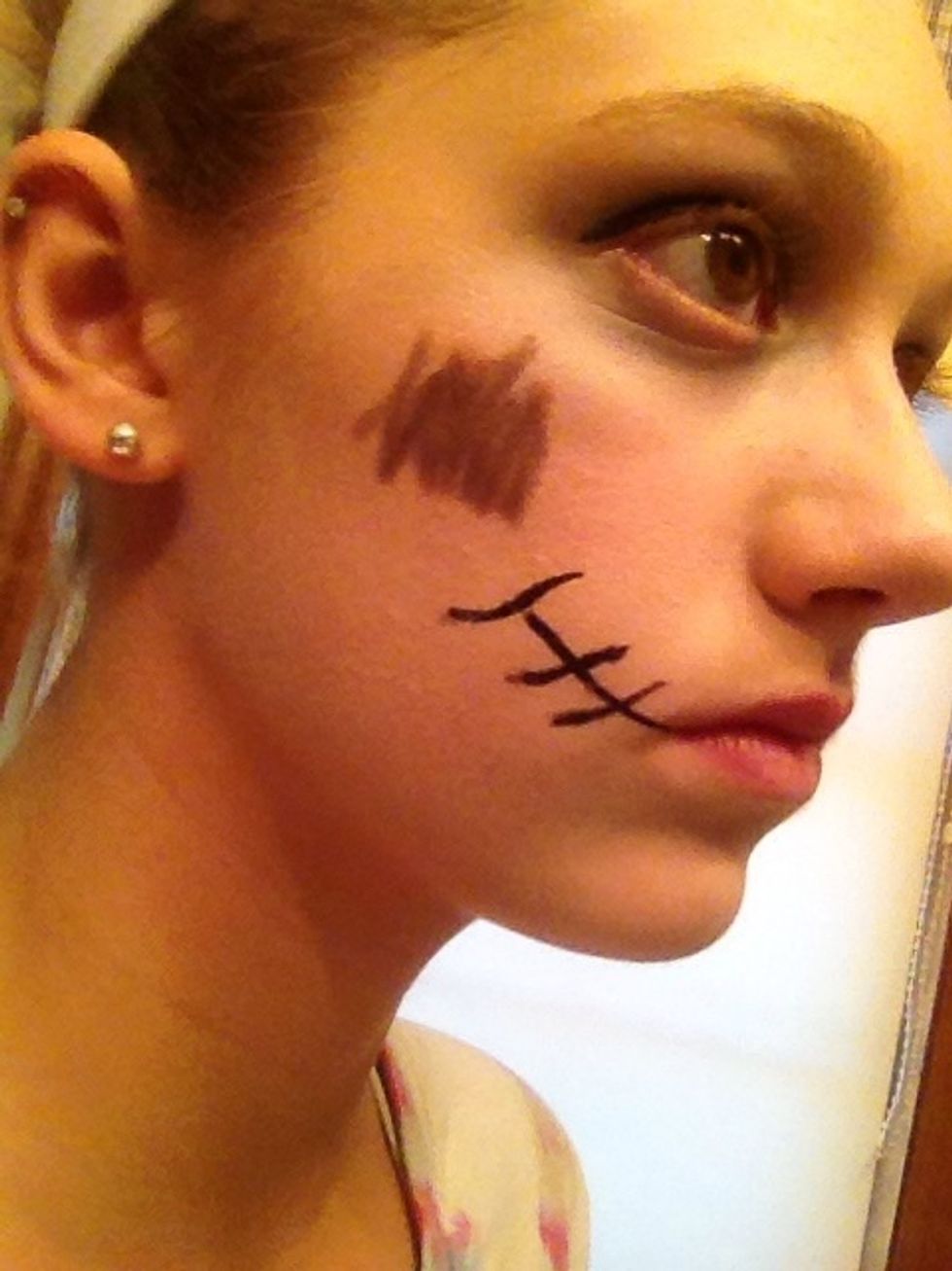 Scribble brown eyeliner on the side of your face for a bruise.