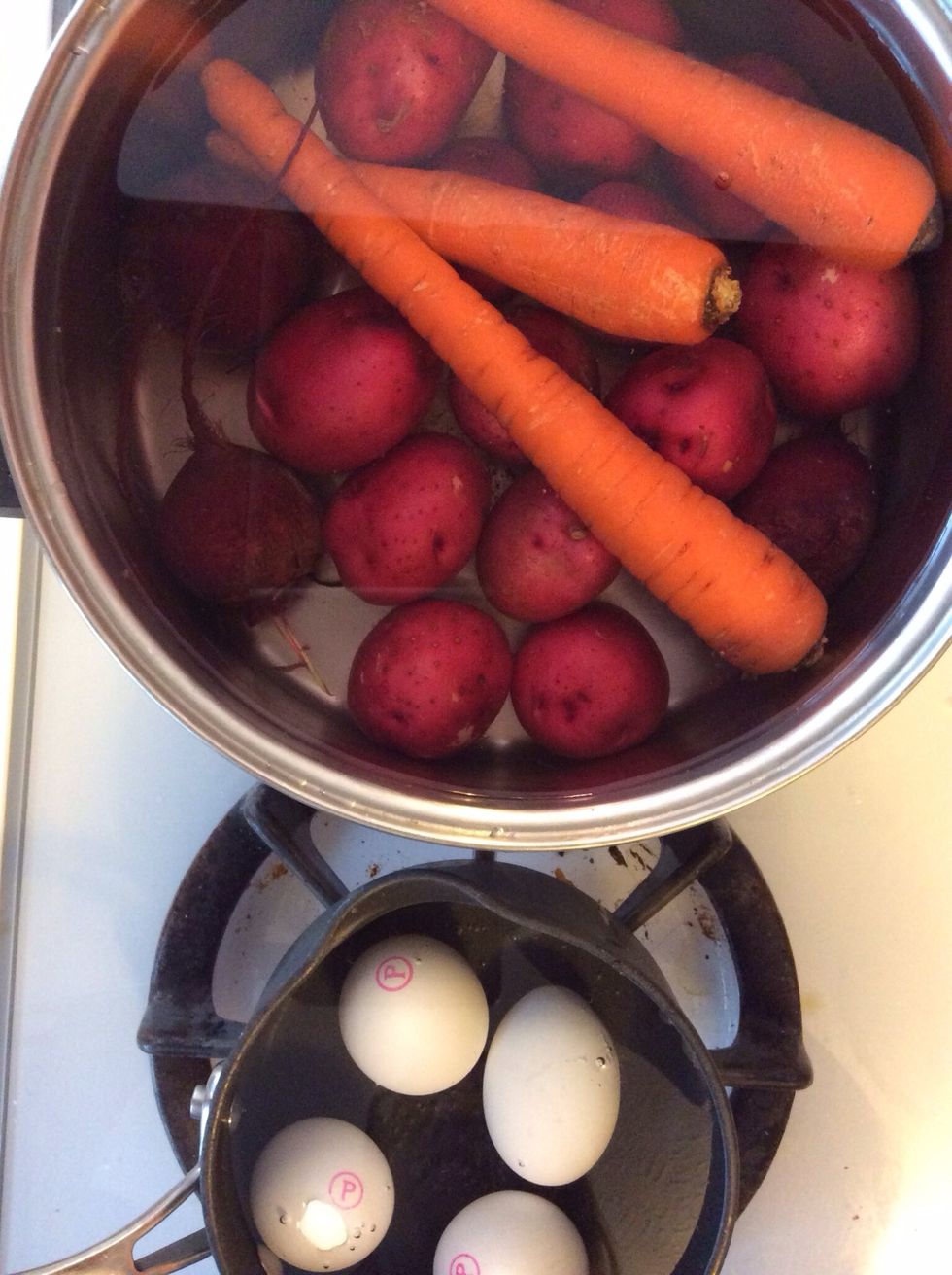 Scrub all the veg (leave the skin on) and cover in a pot with water. Start the eggs in a separate pot. I boil the eggs for about 8 minutes then run under cold water (make a couple extra to use later).