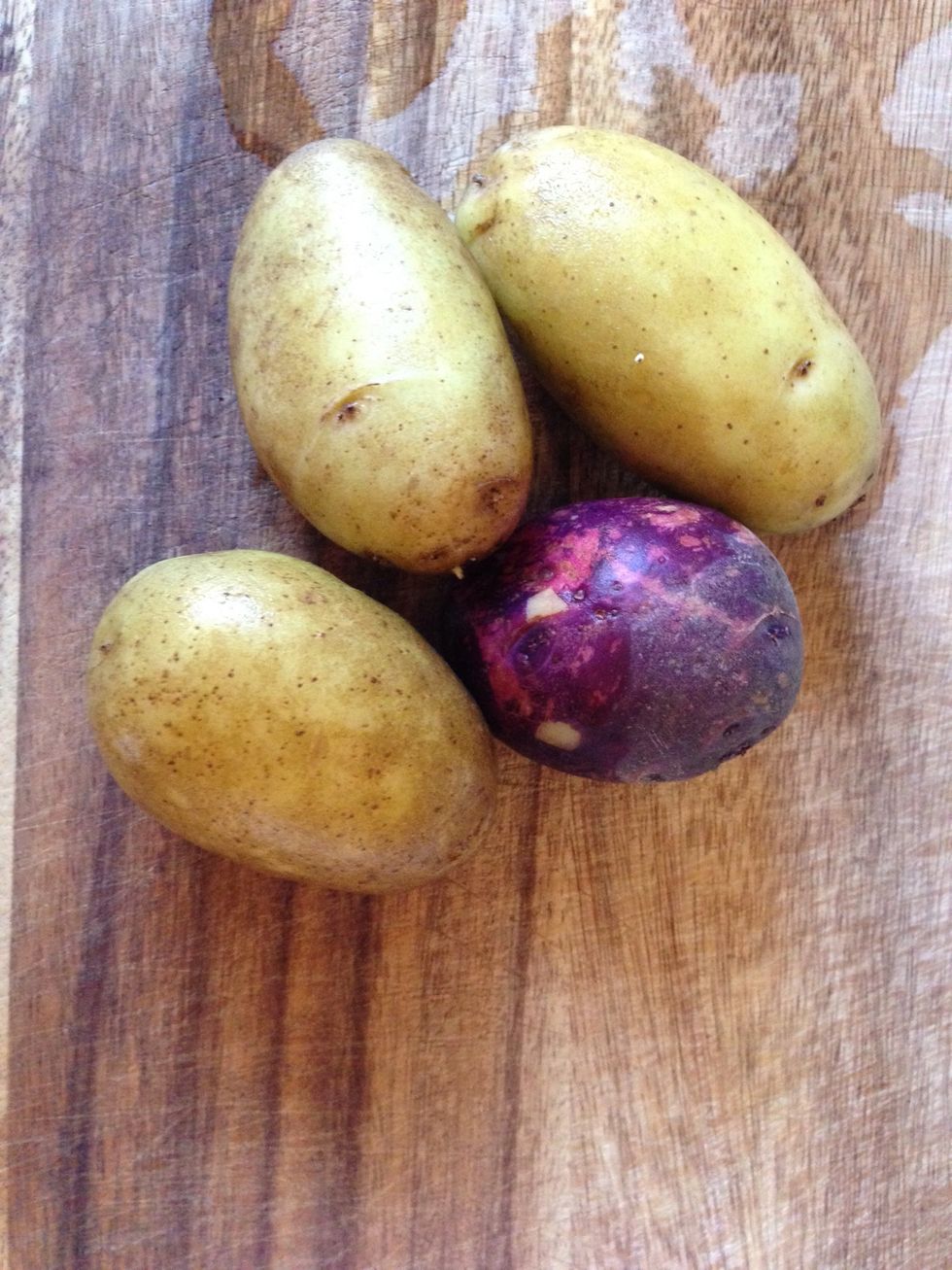 Scrub (using a brush) and wash the potatoes well. Use 1 small or 1/2 of a large potato per person. Use any baking variety potato, like Russet, Viking, or Yukon Gold. Pictured: purple Viking and Yukon.