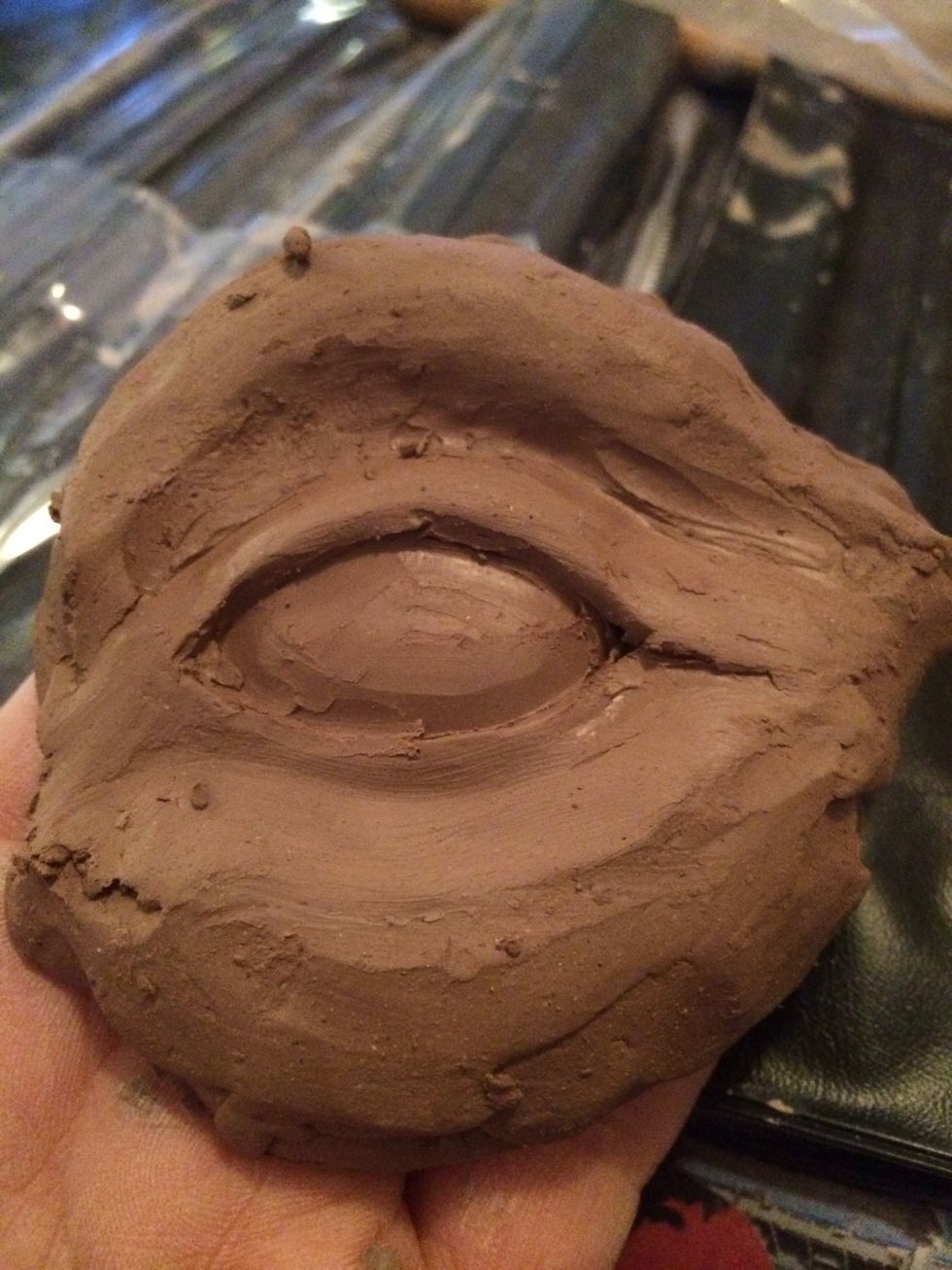 Sculpt the eye ball with a small tool to create a rounded look. Build and shape the corners of the eyes including the tear duct.