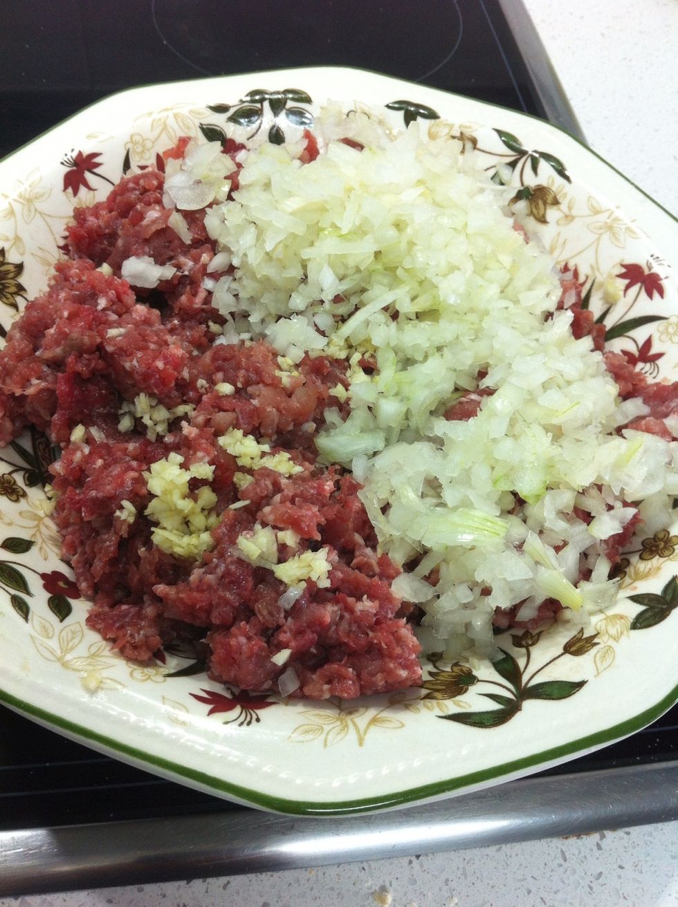 Se a\u00f1ade la cebolla y el ajo picados a la carne y se mezcla todo muy bien.