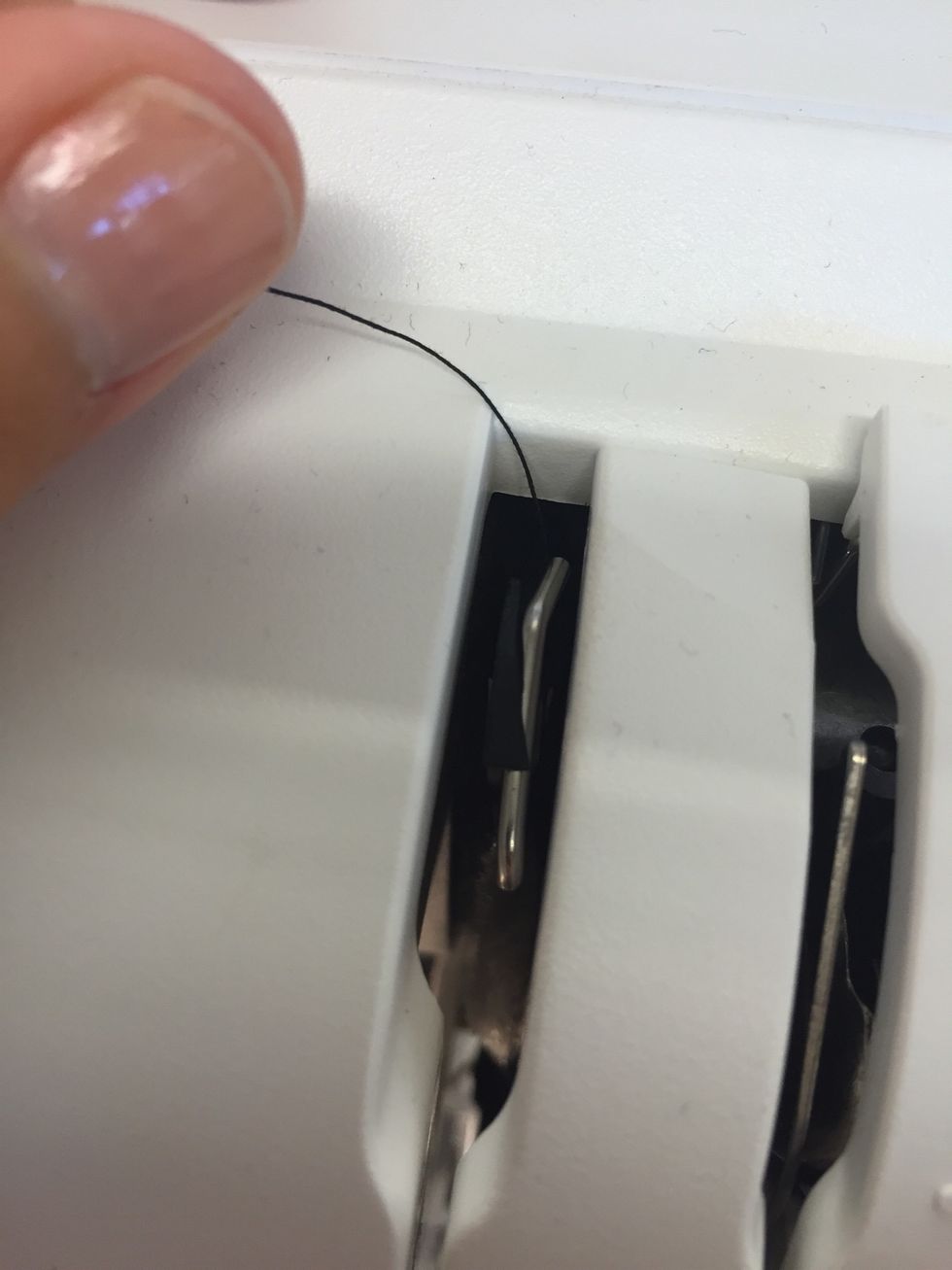 Se till att l\u00e4gga tr\u00e5den \u00f6ver metallkorken som finns i sk\u00e5ran.