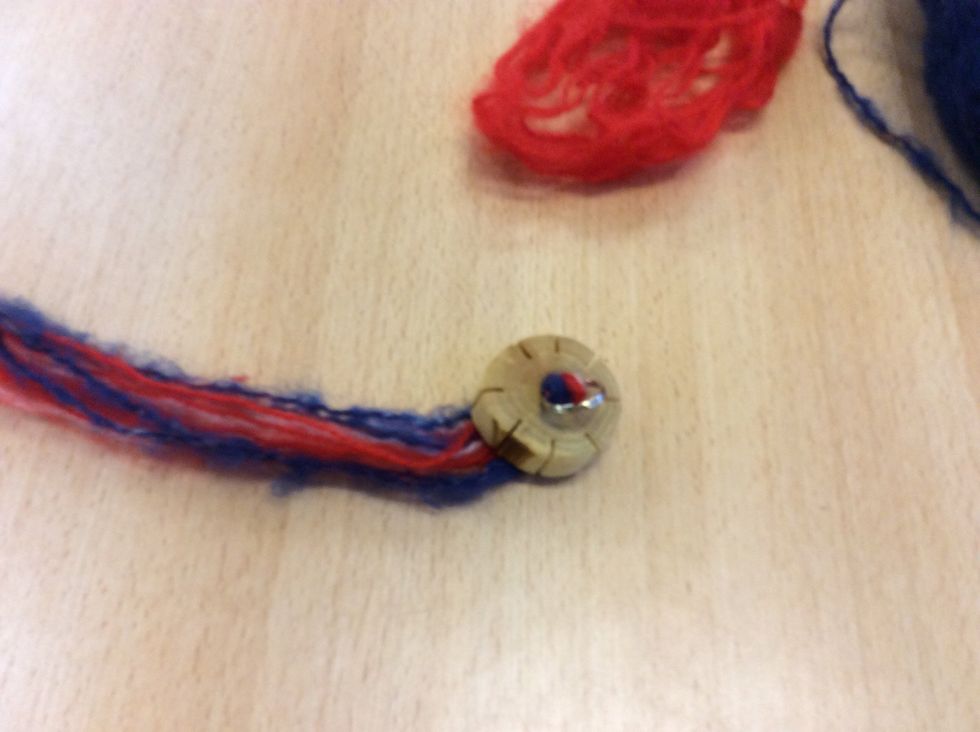 Se till s\u00e5 nyckelringen hamnar i mitten p\u00e5 garnet i h\u00e5let.