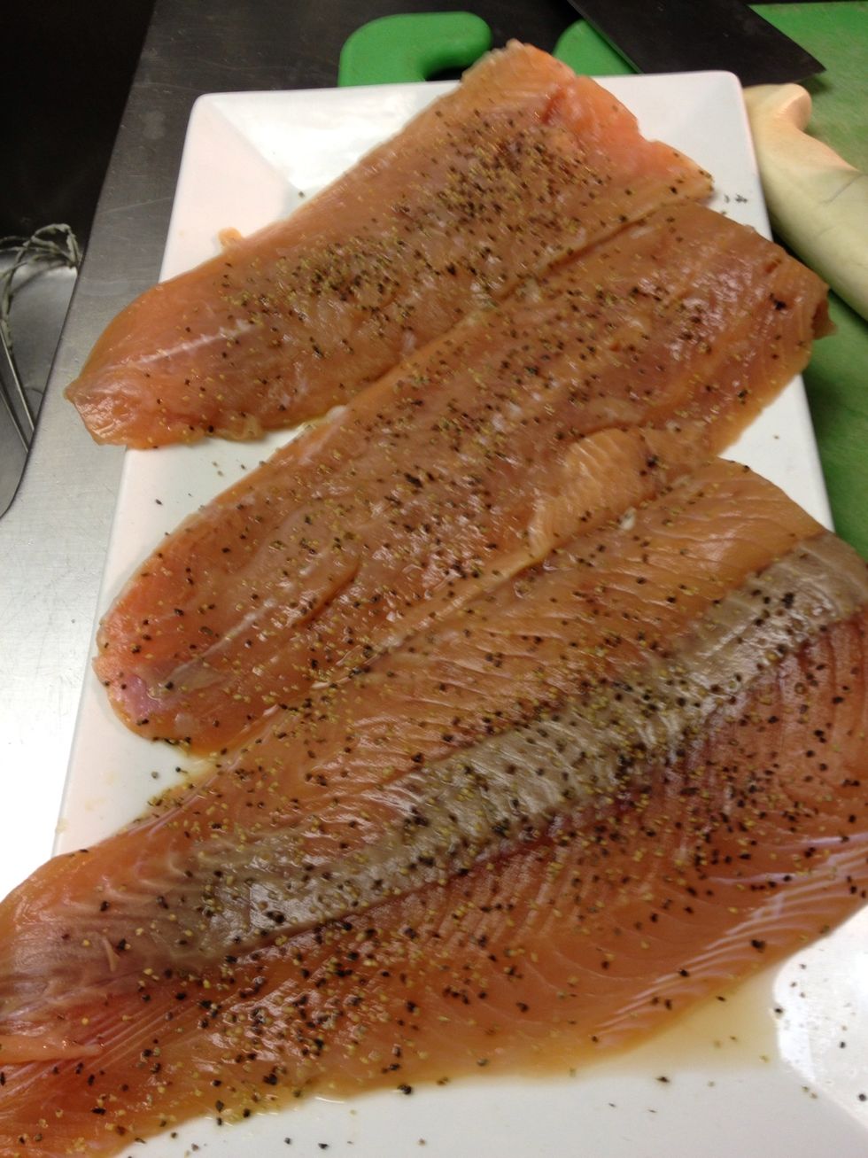 Season salmon with salt and pepper