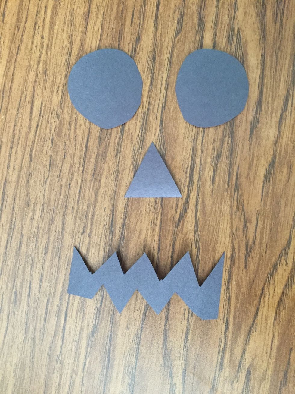 Second, cut out the traced face shapes from the black construction paper.