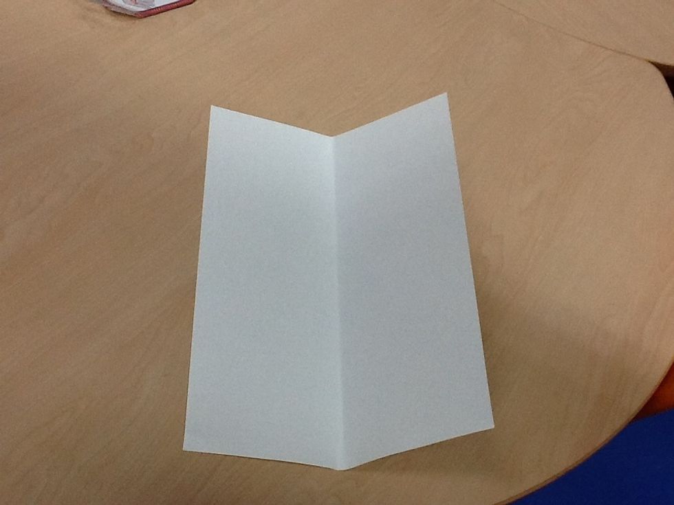 Second, fold the paper in half.