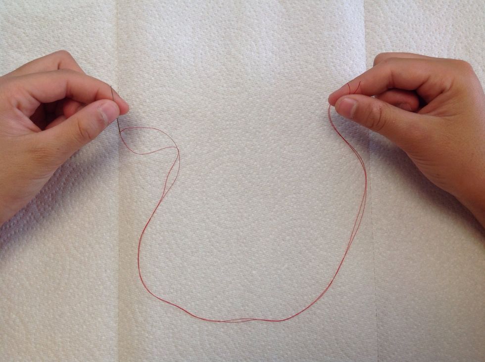 Second, pull the thread end to meet the long end so that they are the same length.