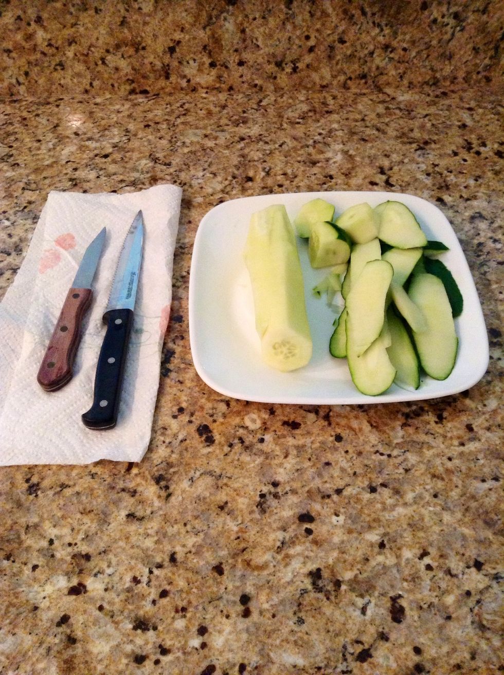 Second, wash the cucumber. Third, peel the protective skin layer off. Fourth, cut the firm ends off.