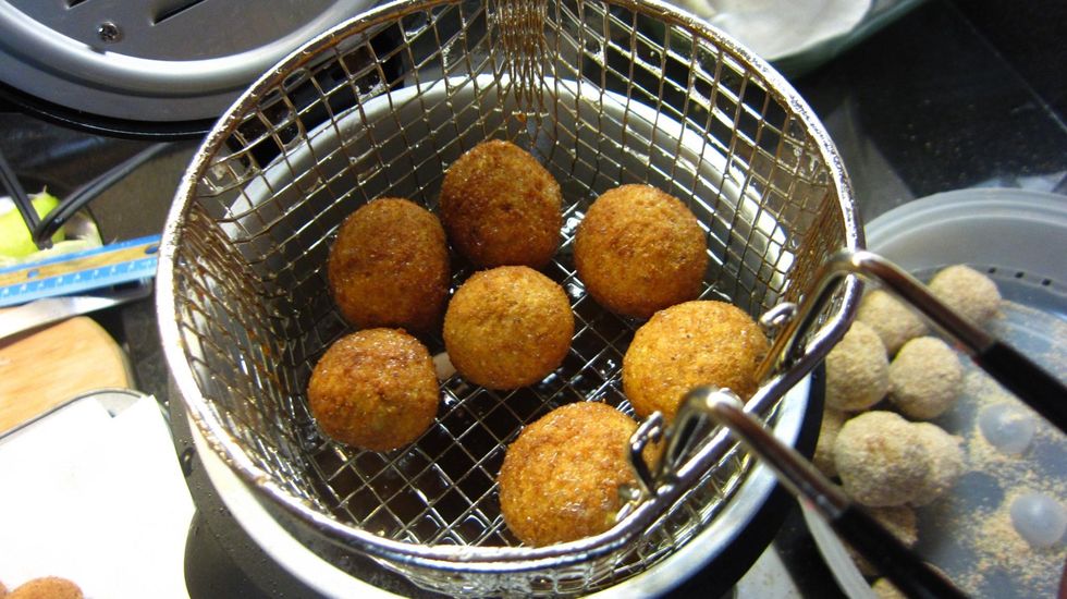 See the lovely Golden brown color? Lift up and hold the drain basket over the oil for 10 seconds so any excess oil drains before you remove the cutlets.