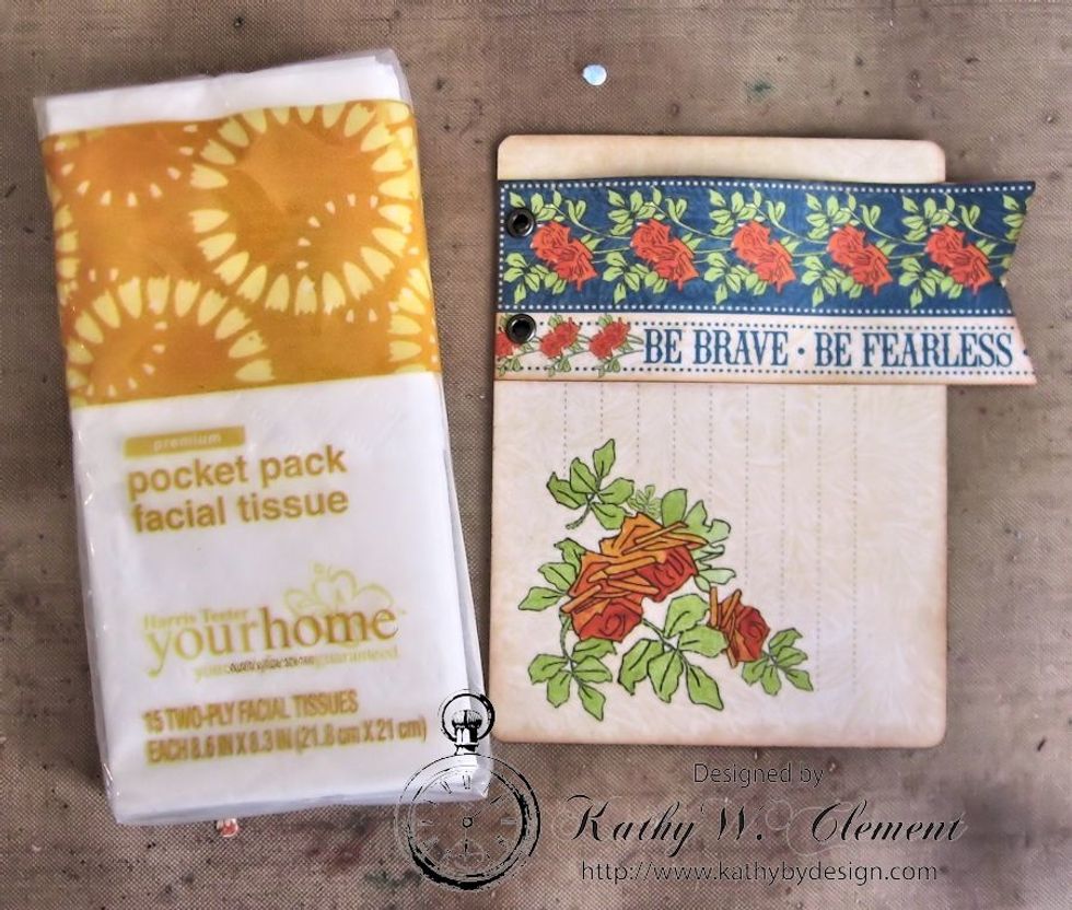 Select a 3" x 4" ephemera card & ink the edges.  Cut the "Be Brave" border from the 12x12 paper pad.  Cut to size, add fishtail & secure with grommets.  Place over a pocket sized packet of tissues.