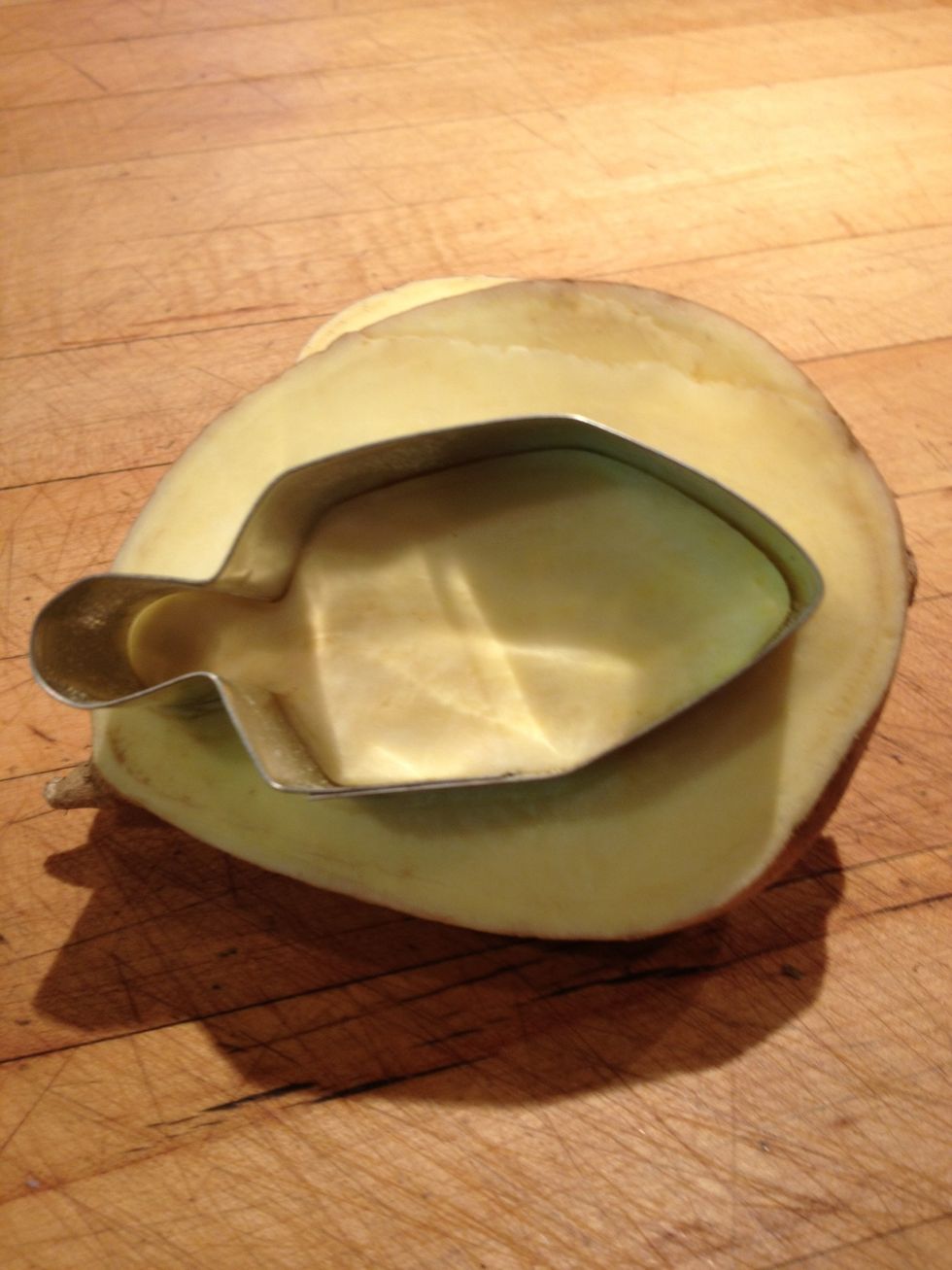 Select a Chanukah cookie cutter and push it into the potato half. I'm starting with a dreidel.
