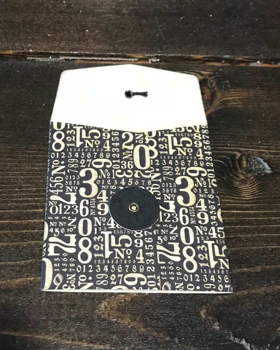 Select a envelope from the package. Trim the envelope to 4 1/4". Trim off the string. Ink the edges of the envelope with black ink.