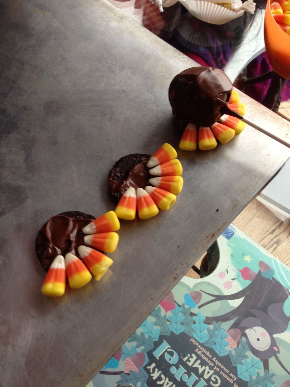 Separate Oreo, take filling out, put melted chocolate and lay candy corn for the tail