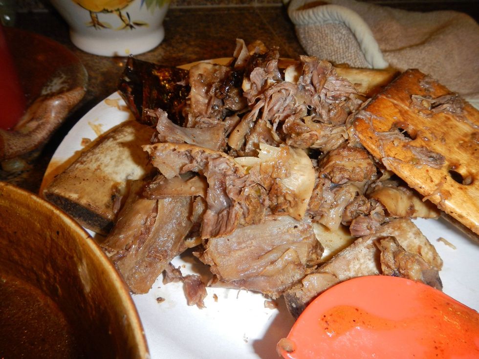 Separate the bones and connective tissue from the succulent, shredded meat and au jus. Keep the au jus in a separate bowl.