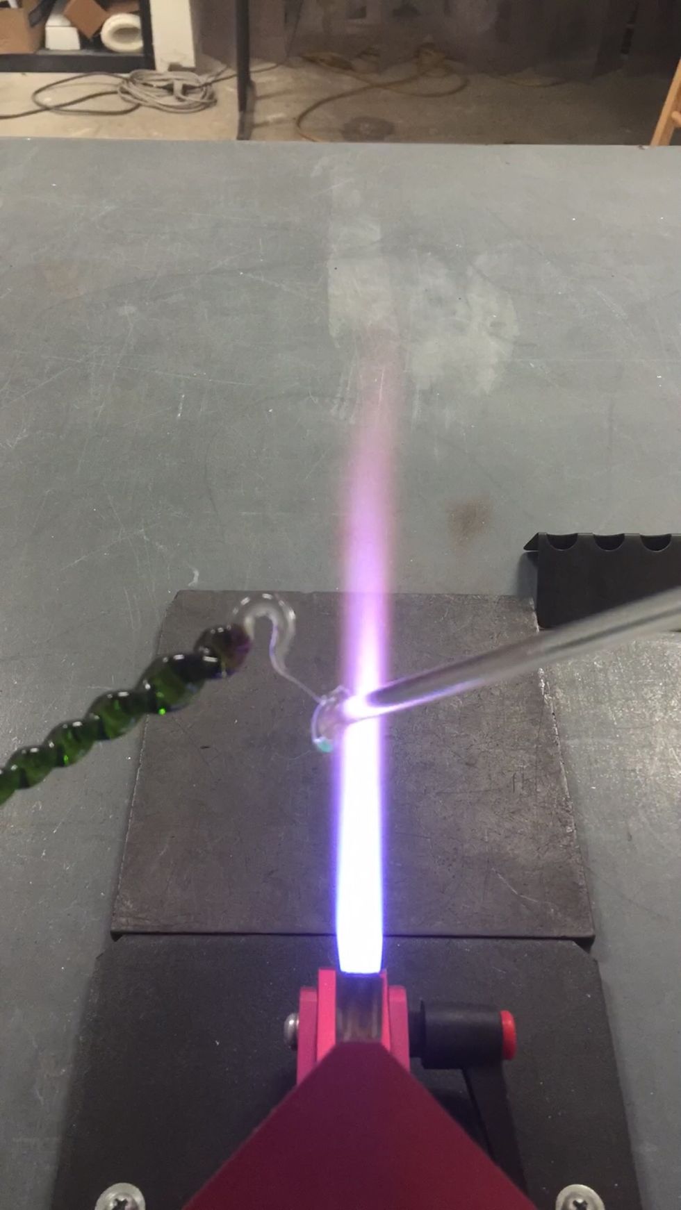 Separate the hook from the punty by heating the thinnest part and continuing to pull the icicle and the punty away from each other.