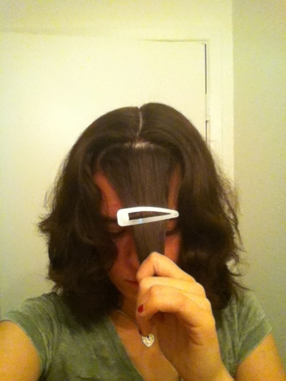 Separate your bangs and part your hair down the middle, all the way down the back.