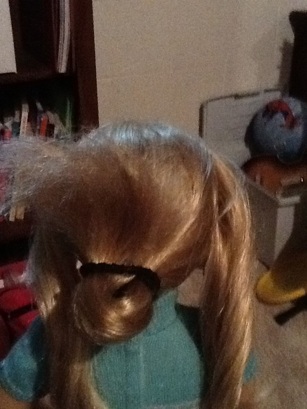 Separate your hair into two sections and then tie back the section in the middle