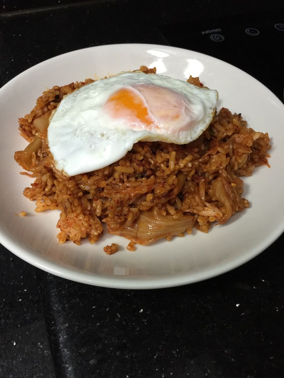 Serve Kimchi Fried Rice on a plate. Top it with a fried egg.