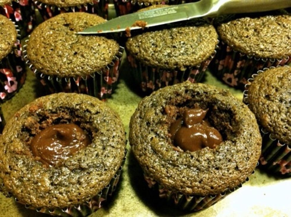 Set ganache aside until cool and thick enough to be piped. Cut out center of cupcakes. Remove core, trim, pipe ganache into centers, and replace core.