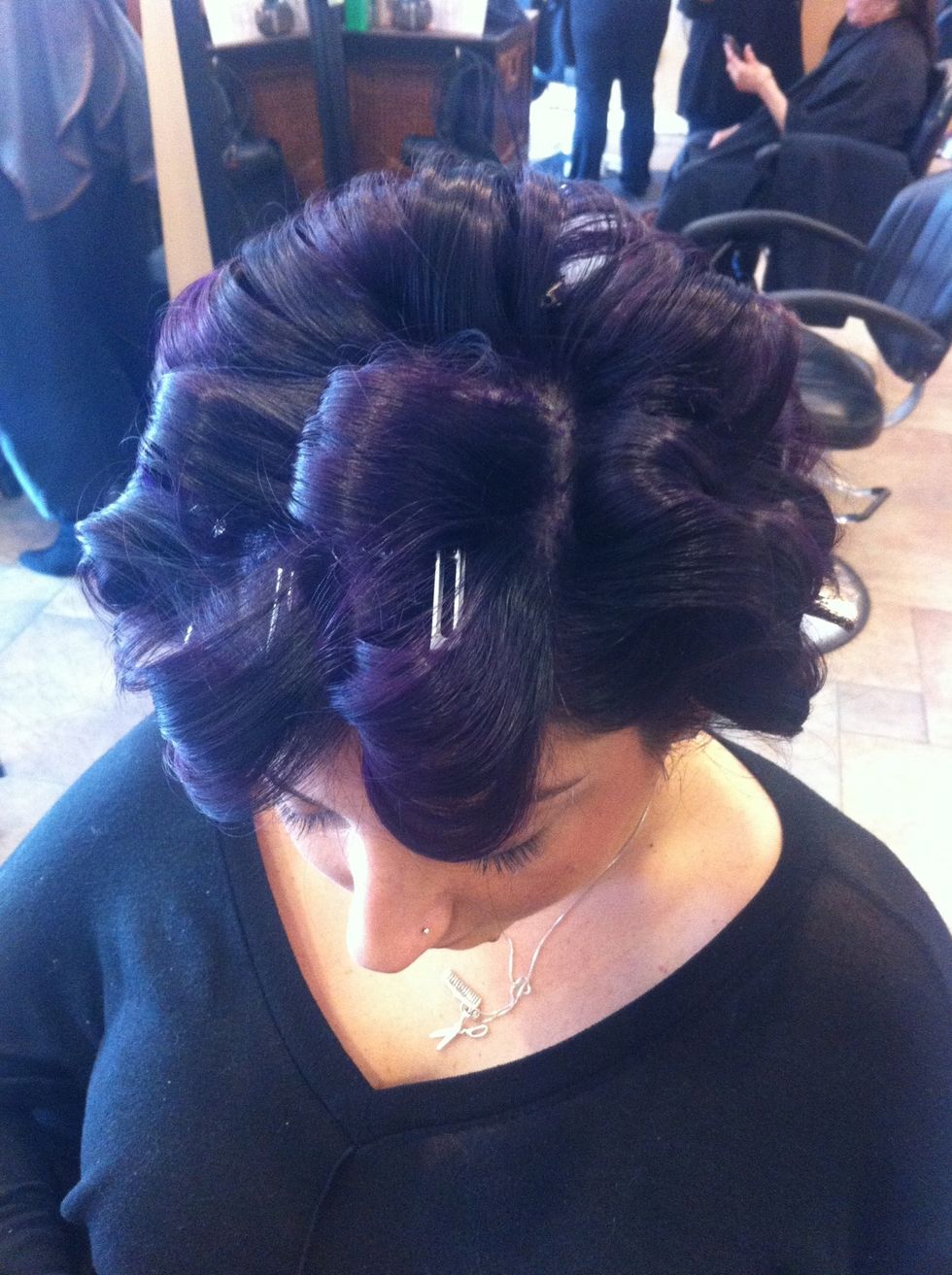 Set hair using a curling iron from a deep side part down the head in a horizontal fashion..