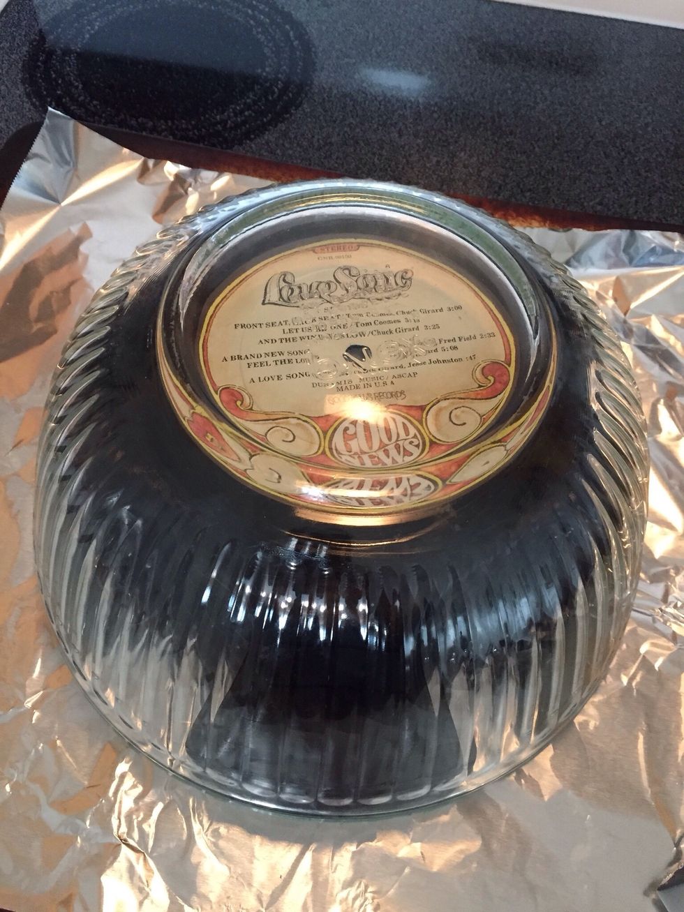 Set larger bowl over the top of the record.  Leave for a few minutes until vinyl has cooled.