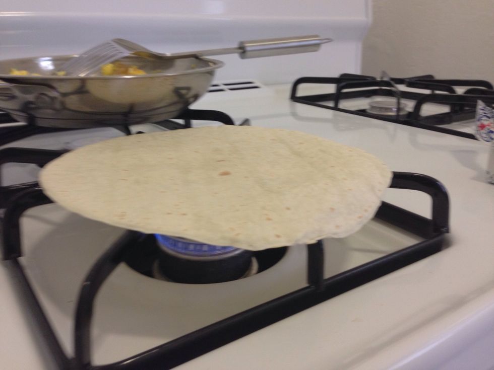 Set mixture aside and while stove is still on heat up tortilla. Just keep flipping it until it is completely warm.