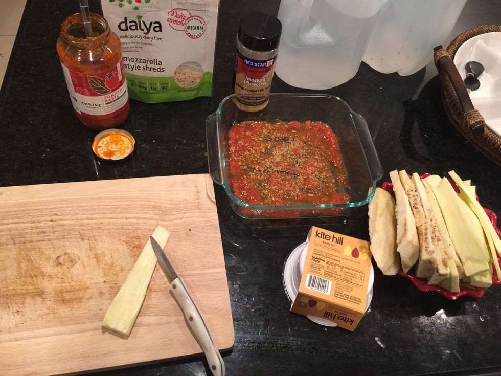 Set out all your ingredients and layer the bottom of the dish with some pasta sauce.